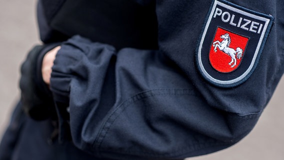 Ein auf einer Jacke aufgebrachter Aufnäher zeigt das Wappen der niedersächsischen Polizei. © dpa Foto: Hauke-Christian Dittrich