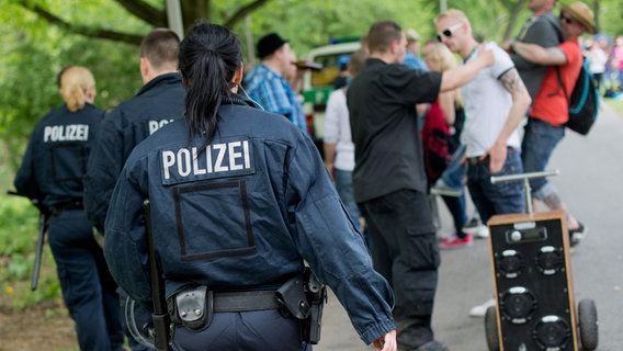 Polizisten gehen an Vatertag-Feiernden vorbei. © picture alliance / dpa | Julian Stratenschulte Foto: Julian Stratenschulte