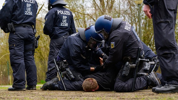 Polizisten der Bundespolizei nehmen während einer Übung einen Fußballfan fest. © dpa Foto: Philipp Schulze