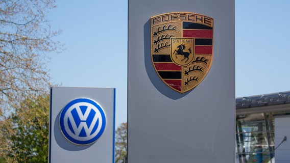An einem Autohaus befinden sich ein Volkswagen Logo und ein Porsche Logo. © picture alliance/Fotostand | Gelhot Foto: Gelhot