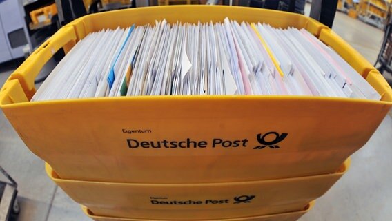 Briefe liegen in Kisten bei der Deutschen Post. © Picture Alliance Foto: Hendrik Schmidt