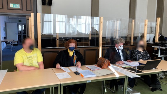 Die angeklagten Eltern sitzen mit ihren Anwälten, Peter Jacobi und Alma Diepoldt in einem Saal im Landgericht in Verden. © NDR Foto: Maren Momsen