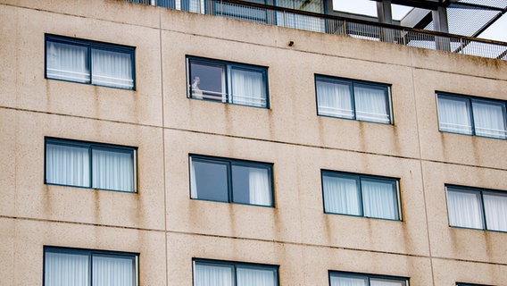 Ein Mann steht in einem Hotel am Fenster. © picture alliance/ROBIN UTRECHT 
