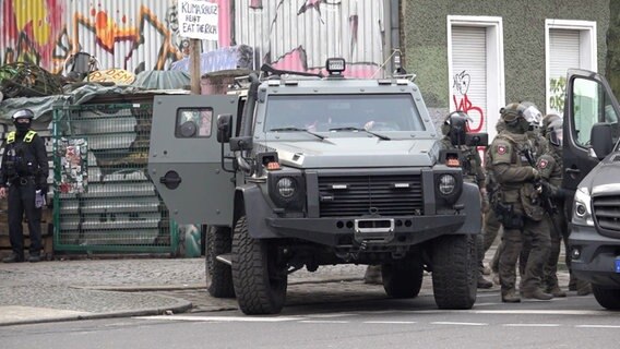 Polizisten stehen in Berlin an einem gepanzerten Fahrzeug. © dpa Bildfunk Foto: Paul Zinken