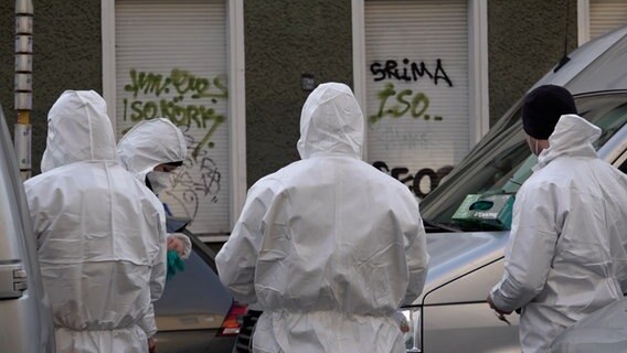 Durchsuchungen im Rahmen der RAF-Fahndung: Einsatzkräfte in weißen Schutzanzügen stehen an einem Grundstück in Berlin © dpa Bildfunk Foto: Paul Zinken