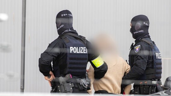 Polizei-Spezialeinsatzkräfte führen eine Angeklagte in das provisorische Gerichtsgebäude in der Außenstelle Sossenheim des Oberlandesgericht Frankfurt. © dpa-Bildfunk Foto: Helmut Fricke