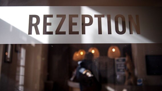 "Rezeption" steht auf der Scheibe eines Hotels am Süstrand von Wilhelmshaven. © picture alliance/dpa | Sina Schuldt Foto: Sina Schuldt