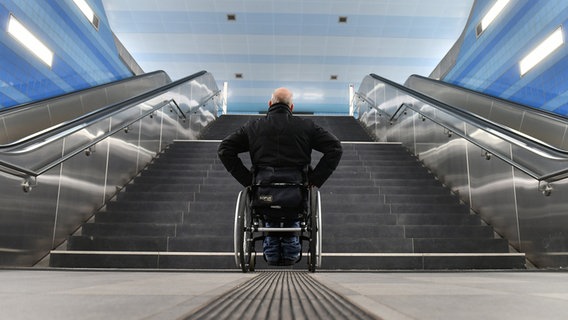 Ein Mann in einem Rollstuhl steht vor einer Treppe. © picture alliance Foto: Frank May
