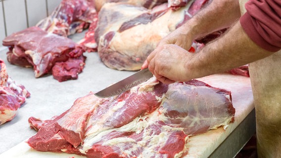 Ein Mann zerlegt in einem Schlachthof Rindfleisch. Ein Mann zerlegt in einem Schlachthof Rindfleisch. © picture alliance/CHROMORANGE/Ernst Weingartner Foto: Ernst Weingartner