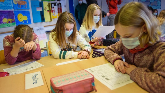 Schülerinnen einer 4. Klasse lesen im Unterricht zusammen eine Aufgabe. © dpa Foto: Gregor Fischer