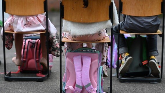 Schulranzen und Rucksäcke stehen bei der Einschulung in die Grundschule Herman-Nohl-Schule in Göttingen unter Stühlen. © picture alliance/dpa/Swen Pförtner Foto: Swen Pförtner