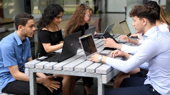 Mehrere Schüler sitzen gemeinsam mit Laptops an einem Tisch. © picture alliance/ROLAND SCHLAGER/APA /picturedesk.com Foto: Roland Schlager