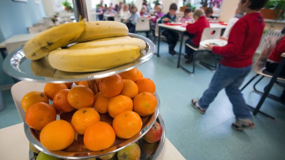 Eine Etagere mit Obst steht während der Mittagspause in der Mensa einer Schulküche. © dpa Foto: Jens Büttner