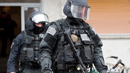 Beamte des Spezialeinsatzkommandos (SEK) der Polizei verlassen ein Wohnhaus. © dpa Foto:  Boris Roessler
