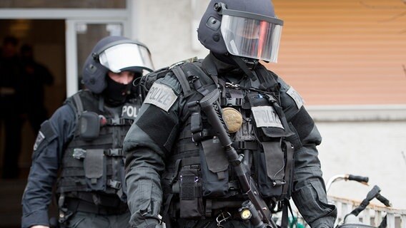 Beamte des Spezialeinsatzkommandos (SEK) der Polizei verlassen ein Wohnhaus. © dpa Foto:  Boris Roessler