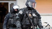 Beamte des Spezialeinsatzkommandos (SEK) der Polizei verlassen ein Wohnhaus. © dpa Foto:  Boris Roessler