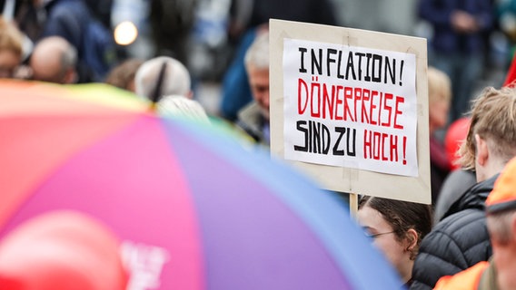 "Inflation! Dönerpreise sind zu hoch!" steht auf einem Schild. © Joerg Carstensen/dpa Foto: Joerg Carstensen/dpa
