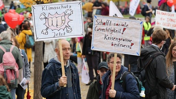 Zwei Personen halten auf einer Demonstration in Berlin Schilder in die Höhe. © Joerg Carstensen/dpa Foto: Joerg Carstensen/dpa