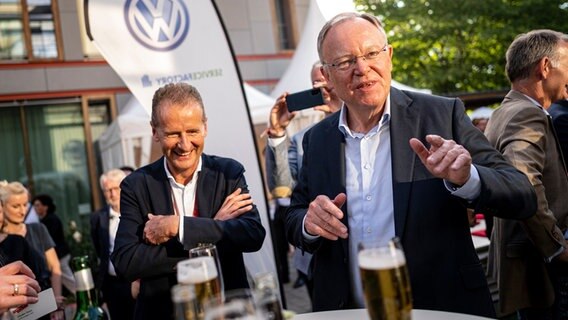 Stephan Weil (SPD - r), Ministerpräsident Niedersachsen, und Herbert Diess, Vorstandsvorsitzender der Volkswagen AG, stehen auf dem Sommertreff in der niedersächsischen Landesvertretung. © dpa-Bildfunk Foto: Fabian Sommer