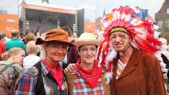 Drei Personen in Western-Kostümen vor der NDR Bühne der Sommertour 2015 in Lingen © NDR Foto: Alexander Brodeßer