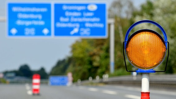 Eine Warnleuchte steht auf einer gesperrten Autobahn.  Foto: Hauke-Christian Dittrich