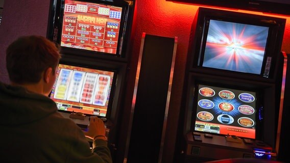 Ein junger Mann spielt an einem Spielautomaten. © picture alliance / Britta Pedersen/dpa-Zentralbild/dpa | Britta Pedersen Foto: Britta Pedersen