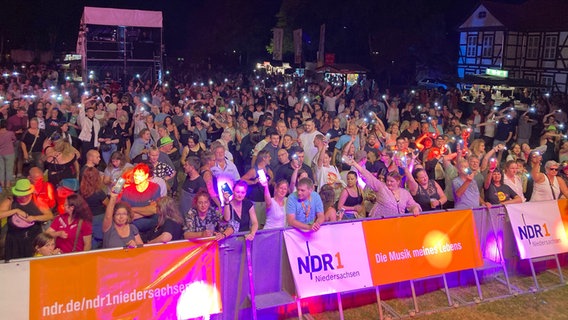 Zahlreiche Menschen stehen bei "Sport vereint uns" vor einer Bühne. © NDR Foto: Stefan Gericke