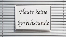 Ein Schild mit der Aufschrift "Heute keine Sprechstunde" hängt im Fenster einer Arztpraxis vor einer Jalousie. © picture alliance/dpa Foto: Sebastian Kahnert