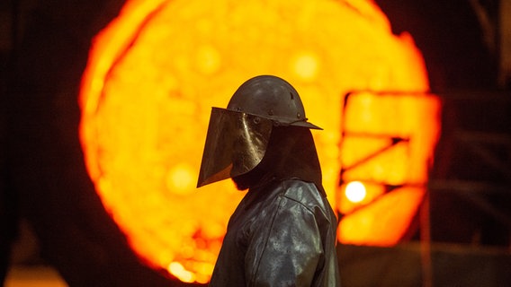 Ein Mitarbeiter steht im Stahlwerk der Salzgitter AG vor einer glühenden Roheisenpfanne. © dpa-Bildfunk Foto: Christophe Gateau/dpa