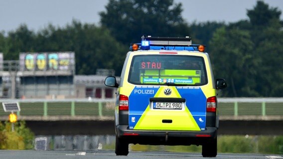 Ein Polizeiwagen steht auf einer Autobahn und signalisiert das Wort "STAU".  Foto: Hauke-Christian Dittrich