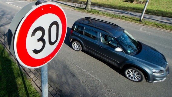 Ein Auto fährt an einem Verkehrsschild für eine Geschwindigkeitsbegrenzung von 30 Stundenkilometer vorbei. © picture alliance/dpa Foto: Julian Stratenschulte