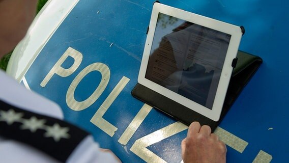 Eine Polizistin bedient ein Tablet. © dpa - Bildfunk Foto: Swen Pförtner