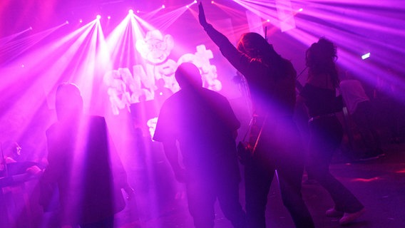 Menschen tanzen in einem Club. © picture alliance Foto: Henning Kaiser