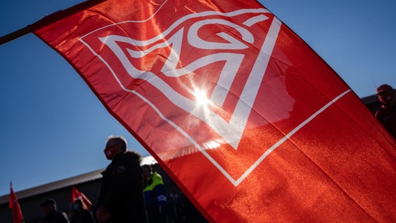 Eine Fahne der IG Metall ist bei einem Warnstreik zu sehen. © picture-alliance Foto: Nicolas Armer
