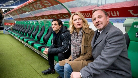 Die Schauspieler Luk Pfaff, Maria Furtwängler und Alexander Held (l-r) posieren in der AWD Arena des Fußball Bundesligisten Hannover 96 während einer Drehpause zu einem neuen Teil der Tatort-Reihe während eines Fototermins. © dpa Bildfunk Foto: Michael Löwa