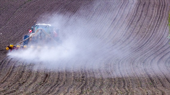 Das Bild zeigt eine Traktor der eine staubwolke auf einem Feld aufwirft. © dpa / picture-alliance Foto: Jens Büttner