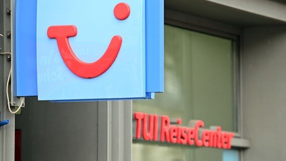 Das Logo des Tui-Konzerns hängt vor einem Reisebüro. © dpa Foto: Soeren Stache