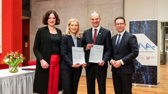Um die Freude über die North West Alliance auszudrücken, stehen Kathrin Moosdorf (Senatorin für Klima, Umwelt und Wissenschaft der Freien Hansestadt Bremen), Jutta Günther (Rektorin der Universität Bremen), Ralph Bruder (Präsident der Universität Oldenburg) und Falko Mohrs (Niedersächsischer Minister für Wissenschaft und Kultur) nebeneinander. Um die Freude über die North West Alliance auszudrücken, stehen Kathrin Moosdorf (Senatorin für Klima, Umwelt und Wissenschaft der Freien Hansestadt Bremen), Jutta Günther (Rektorin der Universität Bremen), Ralph Bruder (Präsident der Universität Oldenburg) und Falko Mohrs (Niedersächsischer Minister für Wissenschaft und Kultur) nebeneinander. © Pressestelle der Universität Oldenburg Foto: Jens Oellermann