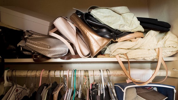 Viele Taschen liegen unordentlich in einem Schrank. © picture alliance/Bildagentur-online/Blend Images/BUILT Images 