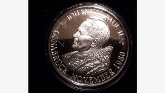 Eine Münze, die anlässlich des Papstbesuches in Osnabrück im Jahre 1980 geprägt wurde, liegt auf einem Tisch. © NDR Foto: Rolf  Fangmeier