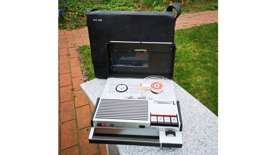 Ein Tonbandgerät liegt auf einem Gartentisch. © NDR Foto: Michael Hahne