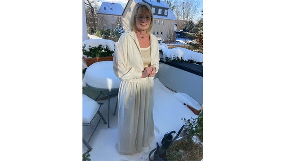 Eine Frau steht im Schnee auf einem Balkon und trägt ein weißes Kleid. © NDR Foto: Sigrid Bormann