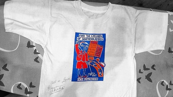 Ein T-Shirt mit einer Grafik und dem Text "Free the Childreen of South Africa - End Apartheit", unterschrieben von der Sängerin Miriam Makeba. © NDR Foto: Thorsten Nack