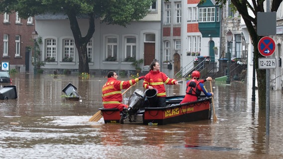 Ein Boot der Deutschen Lebens-Rettungs-Gesellschaft (DLRG) ist bei Hochwasser in Aachen unterwegs. © Ralf Roeger/dmp Press/dpa Foto: Ralf Roeger