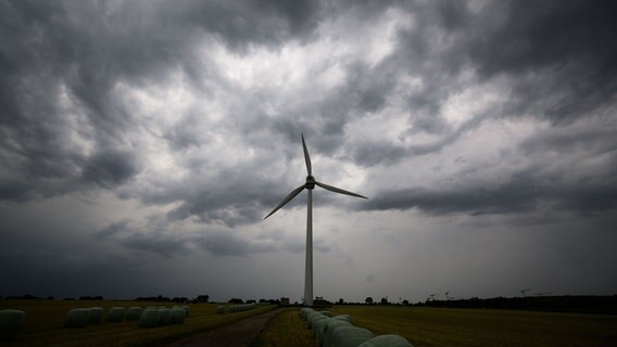 Dunkle Wolken sind am Himmel über einem Windrad zu sehen. © picture alliance/dpa/Julian Stratenschulte Foto: Julian Stratenschulte