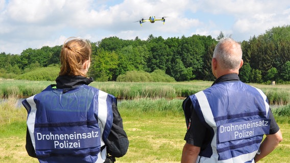 Zwei Polizisten des Drohnenteams stehen auf einer Wiese nahe der Oste. © Polizei Rotenburg 