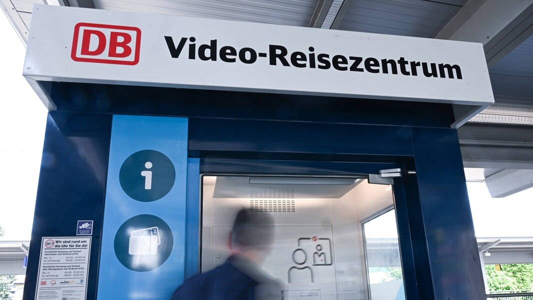 Eine Person geht in ein Video Reisezentrum an einem Regionalbahnhof.