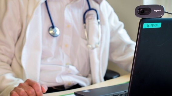 A doctor with a stethoscope around his neck in front of a laptop.  © dpa-Bildfunk Photo: Ole Spata