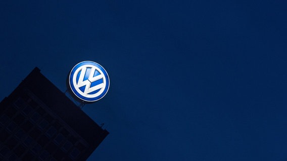 Das Logo des VW-Konzerns leuchtet am Verwaltungshochhaus. © dpa-Bildfunk Foto: Swen Pförtner