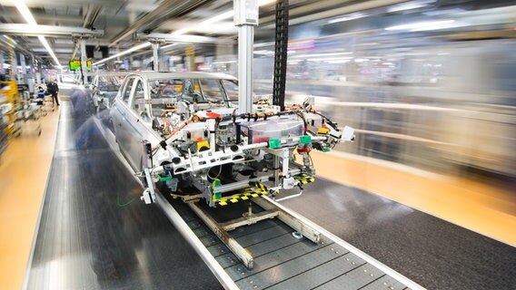 Mitarbeiter montieren Kotflügel an einen Volkswagen Golf VII im Karosseriebau im VW Werk. © picture alliance Foto: Julian Stratenschulte